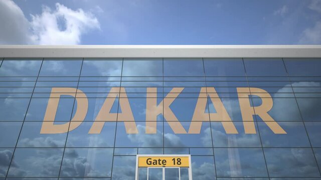 Commercial airplane reflecting in airport terminal with DAKAR text