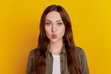 Portrait of dreamy romantic girl send air kiss on yellow background