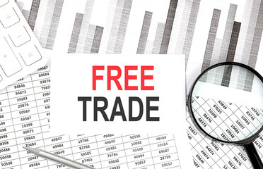FREE TRADE text on paper with calculator,magnifier ,pen on the graph background