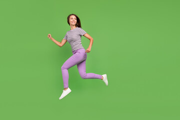 Full length body size view of attractive cheerful girl jumping running active life isolated over bright green color background