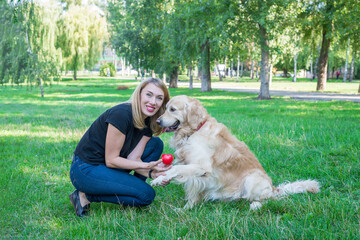 young woman with retriever and red heart in the park.