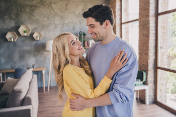 Portrait of attractive sweet cheerful couple spending day free time weekend hugging at home loft industrial interior indoors