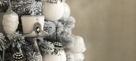 Close up of holidays location with toys, garlands and white gray hat on Christmas tree