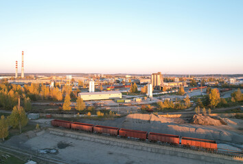 Obraz premium Ready mix concrete batching plant. Producing сoncrete and portland cement mortar for construction and formworks. Freight wagons on a railroad for cement near an industrial plant.