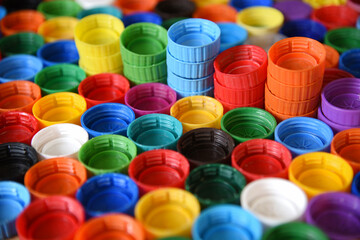 Plastic bottle caps background. Cap material is recyclable.Remove lids from plastic bottles before recycling them. Recycling collection and processing plastic bottle caps