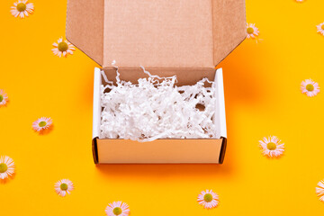 White cardboard box on yellow background empty inside, top view