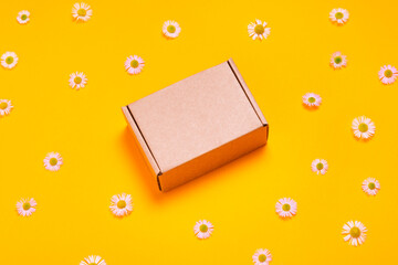 Brown cardboard box on yellow background top view