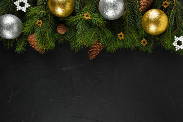 christmas card on a black background spruce branches with ornament cones and stars of gold and silver color