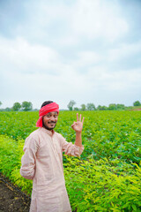 Young indian farmer at green agriculture field.