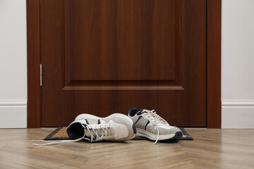 Stylish shoes on door mat in hall