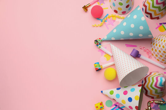 Flat lay composition with party hats and other festive items on pink background. Space for text