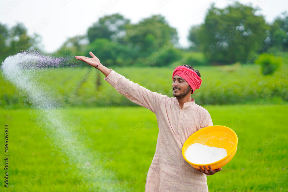 Sticker Indian farmer spreading fertilizer in the agriculture field.