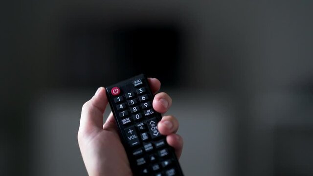 Hand Holding TV Remote Control And Turns Off TV