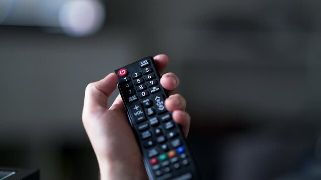 Hand Holding TV Remote Control And Turns Off TV