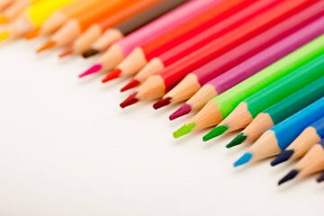School stationery items. Creation Multicolored pencils on a blank white sheet. On a white background. Children's drawing, artist.