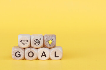 The word GOAL on wooden cube, concept to success of growing business.