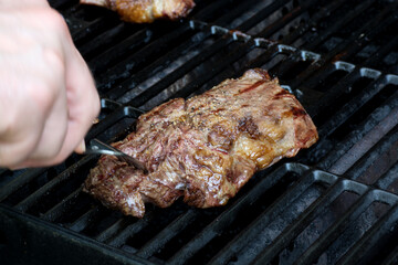 Fresh grilled meat. Grilling steaks on flaming grill