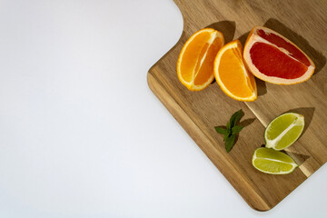 Summer tropical fruit on a wooden chopping board, copy space