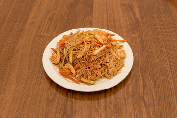 Chinese rice noodles with prawns and vegetables sautéed in the wok and with soy sauce