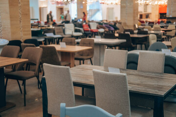 The motion is blurry. Purchase a variety of tables and chairs from different materials at a furniture store. A variety of furniture in shapes, sizes, styles.