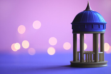 gazebo for lovers with a blue dome on a pink-purple background with bokeh on the right
