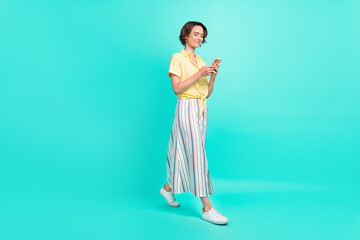 Full body profile side photo of young chat sms smartphone wear long skirt isolated over turquoise color background