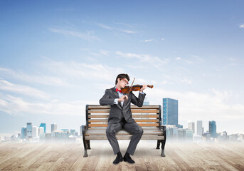 Young businessman plays the violin