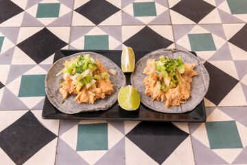 vegan taco with heura, vegetables and lime for dressing on black plate