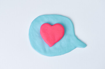 blue speech bubble on white background, in the center there is a pink heart as a sign of love