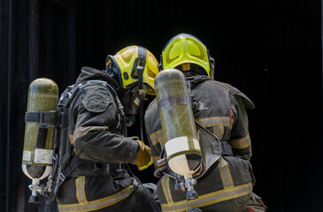 Fireman,Firefighters fighting a fire and spraying high pressure water to fire.