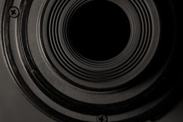 Close up of  the back of a zoom camera lens on a dark background