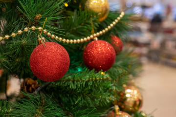 Obraz na płótnie Canvas Christmas tree branch with toy red ball and garland, christmas background for festive design