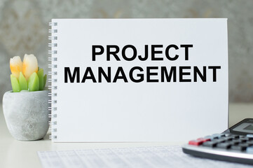 Project management memo written on a notebook on the table