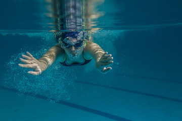 Female swimmer at the swimming pool.Underwater image.
