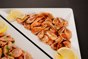 Boiled and fried shrimp on two white plates