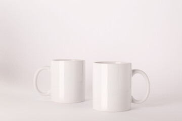 Blank white ceramic mugs on light background