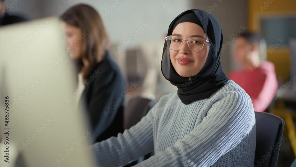 Aufkleber Beautiful Portrait of a Female Muslim Student in Hijab, Studying in University. She Works on Desktop Computer in College. Applying Her Knowledge to Acquire Academic Skills in Class.