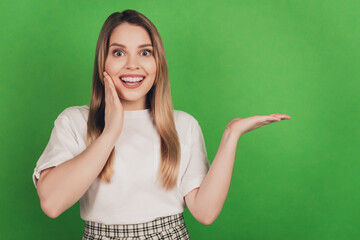 Photo of charming lady hand cheek excited face demonstrate empty space product wear casual clothes