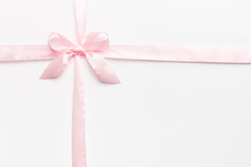 Top view of purple ribbon rolled and pink bow isolated on colored background. Flat lay with copy space