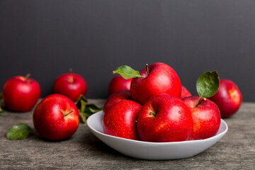 juicy red apples in a bowl or plate on the table top view. Copy space