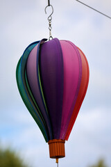 Obraz premium Ein Windspiel in der Form eines Ballon hängt an einer Leine und dreht sich bei Wind.