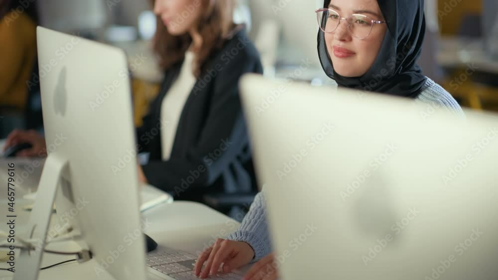 Aufkleber beautiful portrait of a female muslim student in hijab, studying in university. she works on desktop