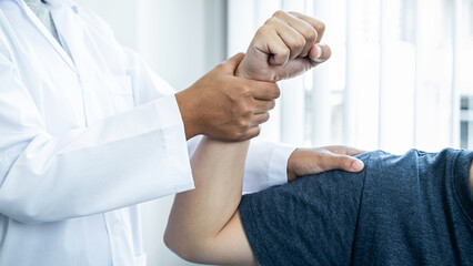 Female physiotherapist doing healing treatment and rehabilitation after injury shoulder of patient by stretching