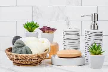 Herb soap, shower sponge and shampoo pump bottle inside a bright bathroom.