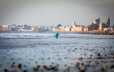 Surfer coming out of the water in Cortadura's Beach, Cadiz, Spain.