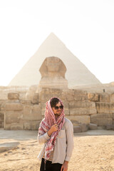 Male traveler in front of pyramids of Egypt