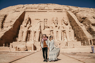 Traveling Couple exploring Abu Simbel ancient temple in Egypt - obrazy, fototapety, plakaty
