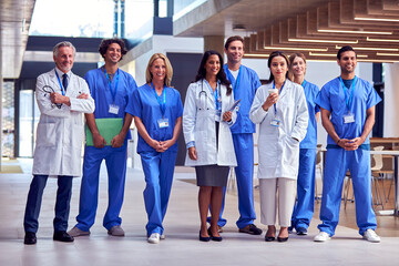 Portrait Of Multi-Cultural Medical Team Wearing Uniform Standing Inside Hospital Building
