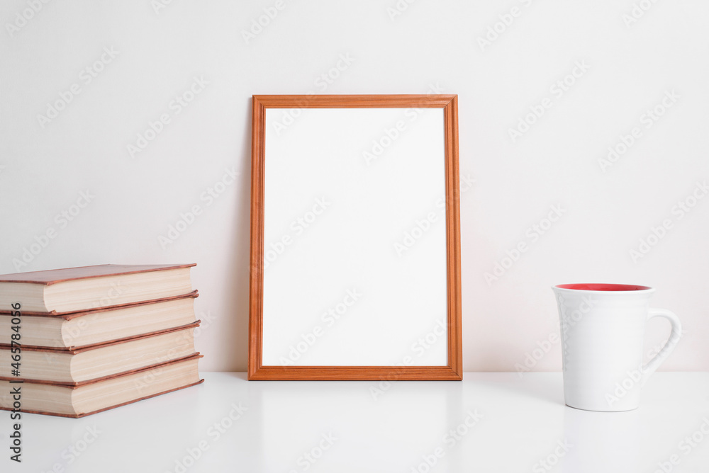 Poster portrait vertical blank frame mock up. books, cup of coffee or tea and white picture template with e