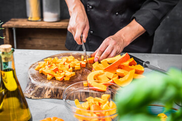 Chef cutting fresh and delicious pumkin and vegetables for cooking soup